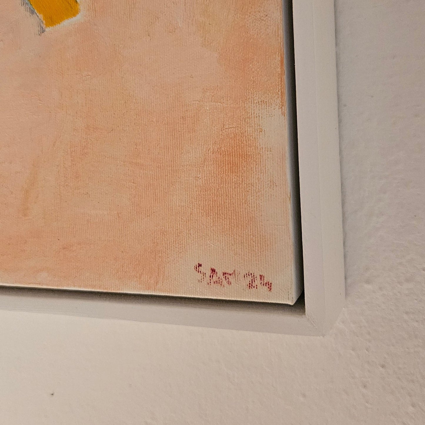 Corner of painting with white frame with artist's name, Sam 24.